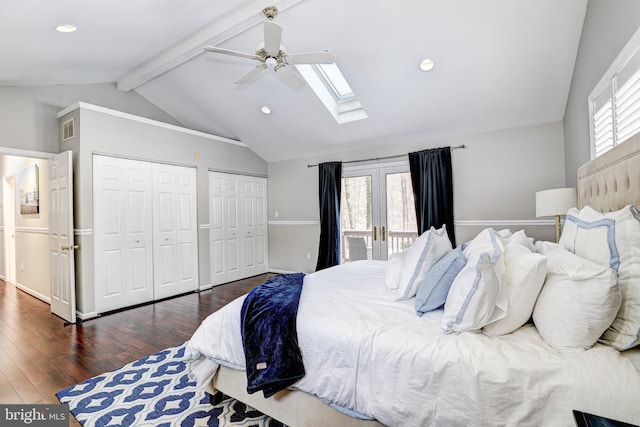 bedroom featuring ceiling fan, vaulted ceiling with skylight, dark hardwood / wood-style flooring, french doors, and multiple closets