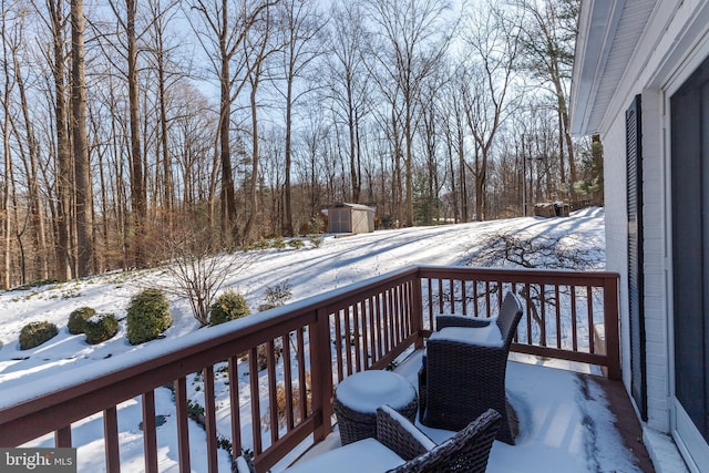 snow covered deck with a shed