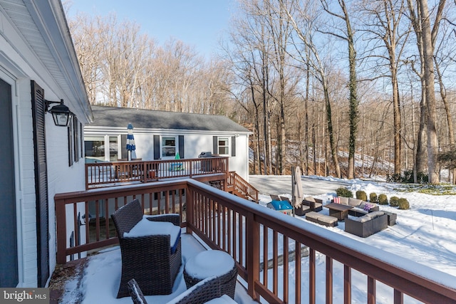 snow covered deck featuring an outdoor living space with a fire pit