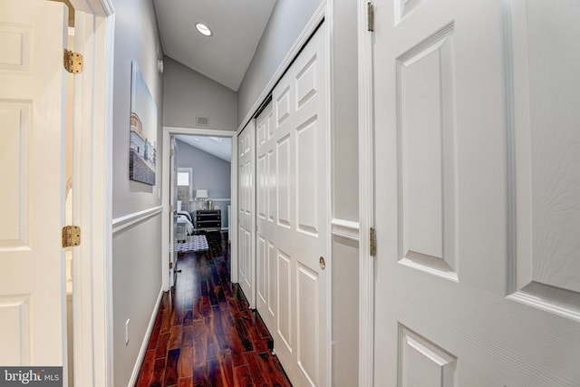 hallway featuring dark hardwood / wood-style flooring and vaulted ceiling