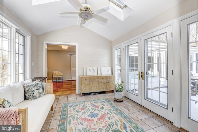 sunroom with lofted ceiling with skylight, french doors, and ceiling fan