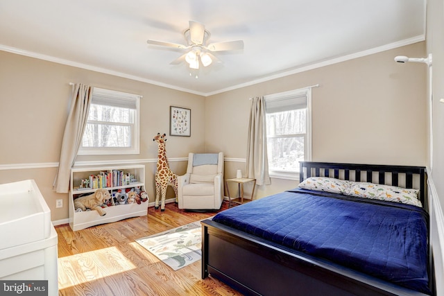 bedroom featuring multiple windows, crown molding, and light hardwood / wood-style floors