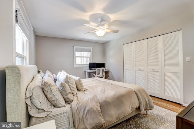 bedroom with ceiling fan, light hardwood / wood-style floors, and a closet