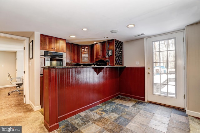 kitchen with stainless steel oven and kitchen peninsula