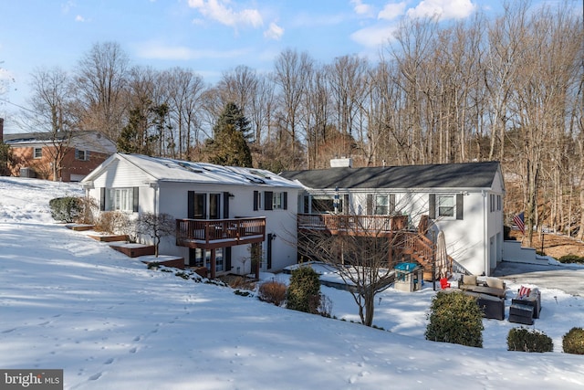 snow covered house featuring a deck