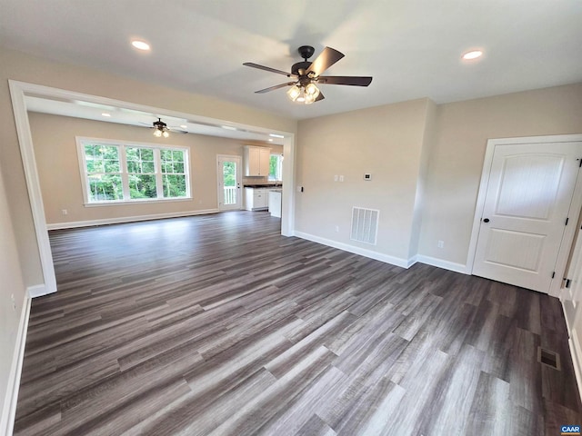 unfurnished living room with ceiling fan and dark hardwood / wood-style flooring