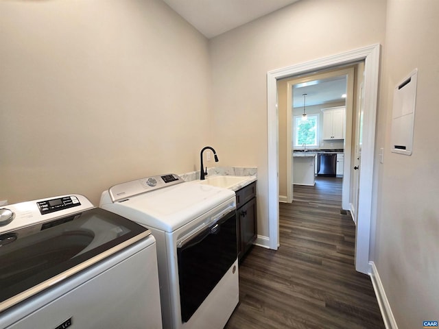 clothes washing area featuring separate washer and dryer, sink, dark wood-type flooring, and cabinets