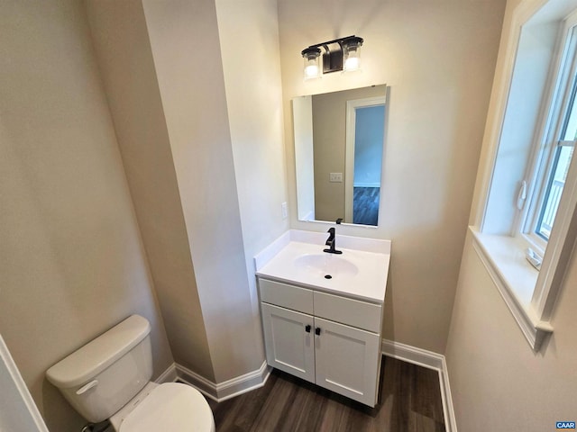 bathroom with hardwood / wood-style flooring, vanity, and toilet