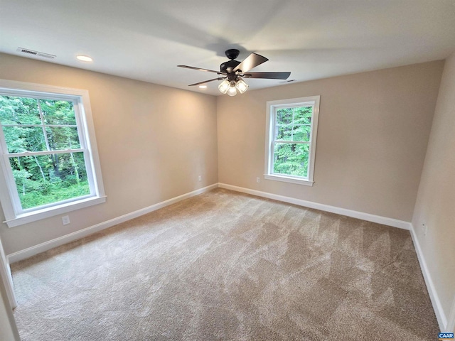 carpeted empty room with ceiling fan and a healthy amount of sunlight