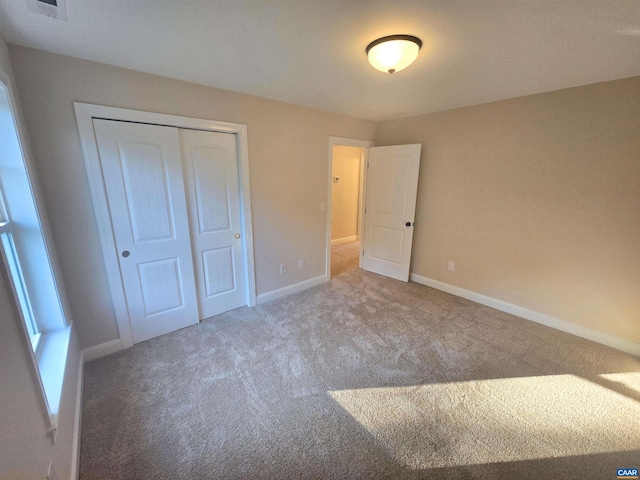 unfurnished bedroom featuring carpet flooring and a closet