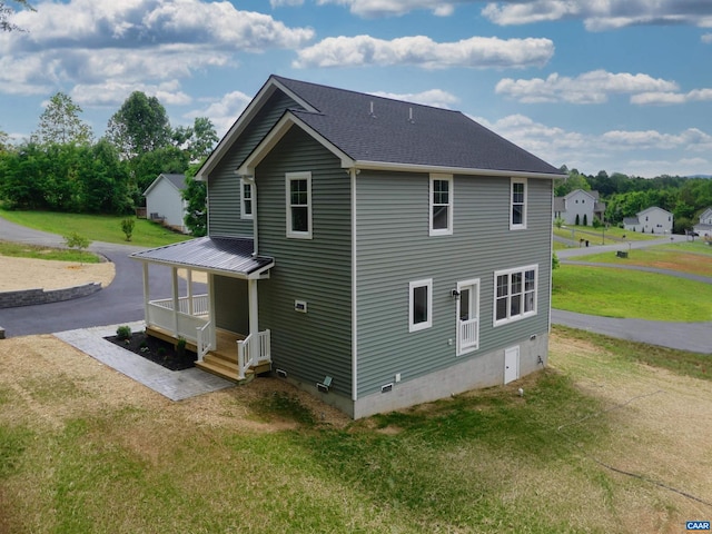 rear view of house featuring a porch and a yard