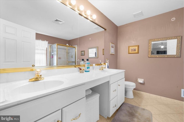 bathroom featuring tile patterned flooring, vanity, toilet, and a shower with shower door