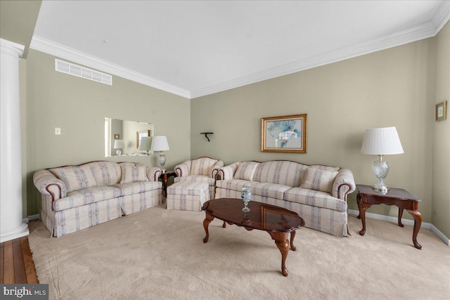 carpeted living room with crown molding and ornate columns