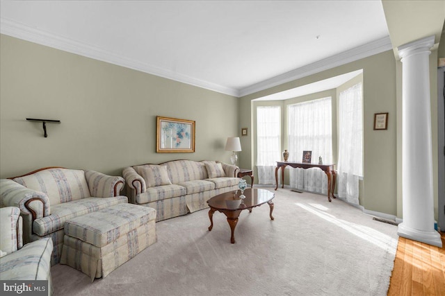 living room featuring ornate columns, ornamental molding, and light hardwood / wood-style floors