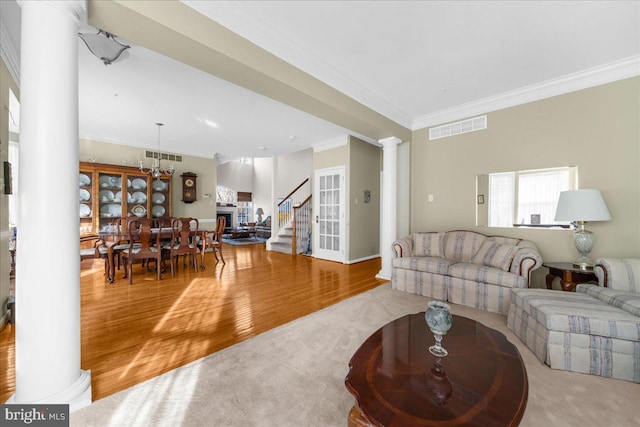 living room featuring hardwood / wood-style floors, ornamental molding, and decorative columns