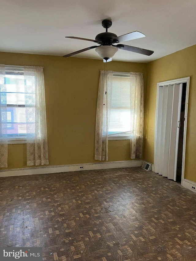 empty room featuring plenty of natural light and ceiling fan