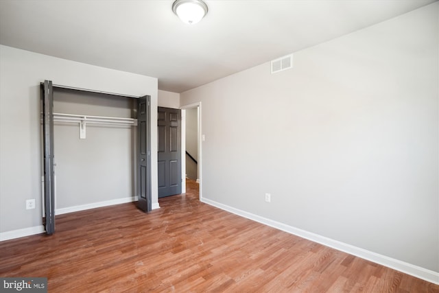 unfurnished bedroom with wood-type flooring and a closet