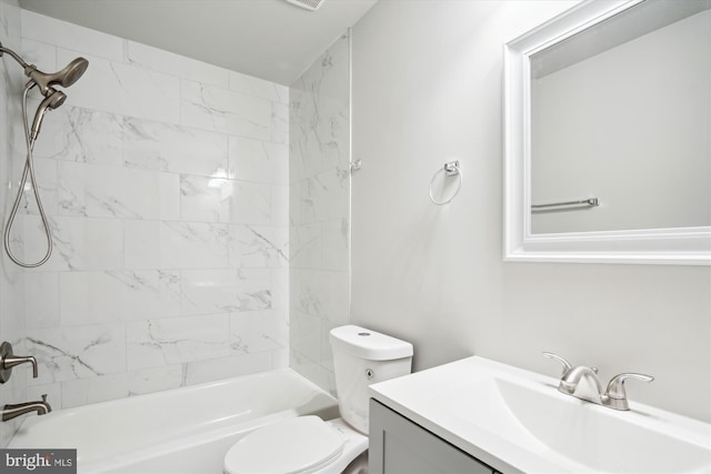 full bathroom featuring tiled shower / bath, vanity, and toilet