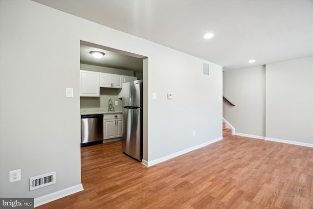 spare room featuring sink and light hardwood / wood-style flooring