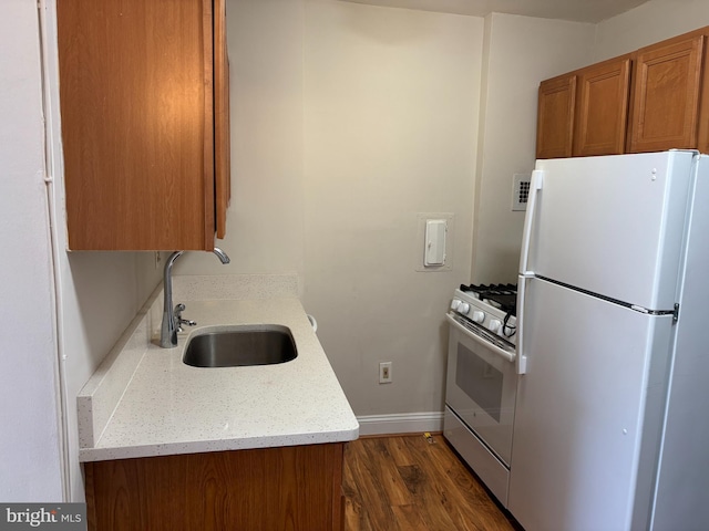 kitchen with sink, dark wood-type flooring, and white appliances