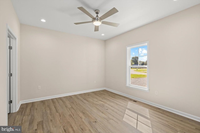 empty room with ceiling fan and light hardwood / wood-style flooring