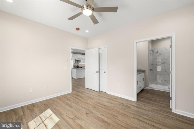 unfurnished bedroom featuring ceiling fan, ensuite bathroom, and light hardwood / wood-style floors