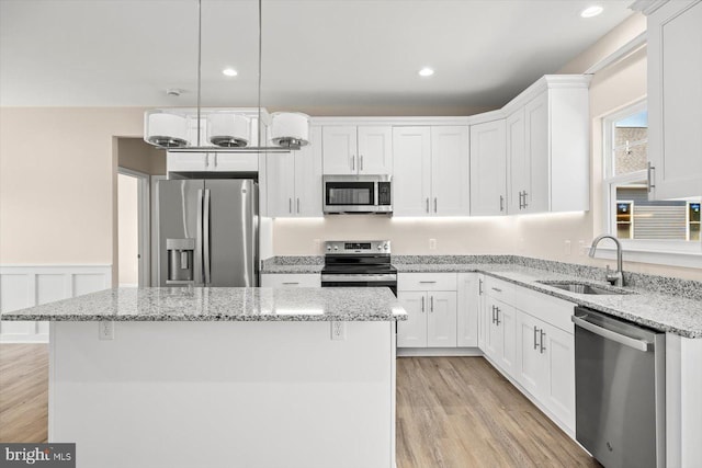 kitchen with white cabinetry, sink, a center island, and appliances with stainless steel finishes