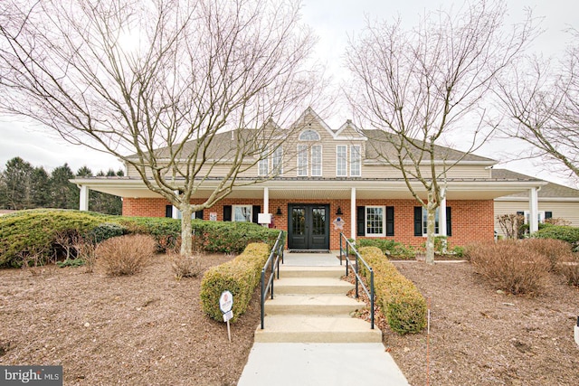 view of front of house with brick siding and french doors