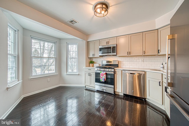 kitchen featuring dark wood-style floors, light countertops, visible vents, decorative backsplash, and appliances with stainless steel finishes