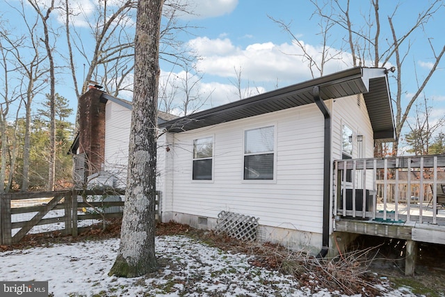 view of snowy exterior with a wooden deck