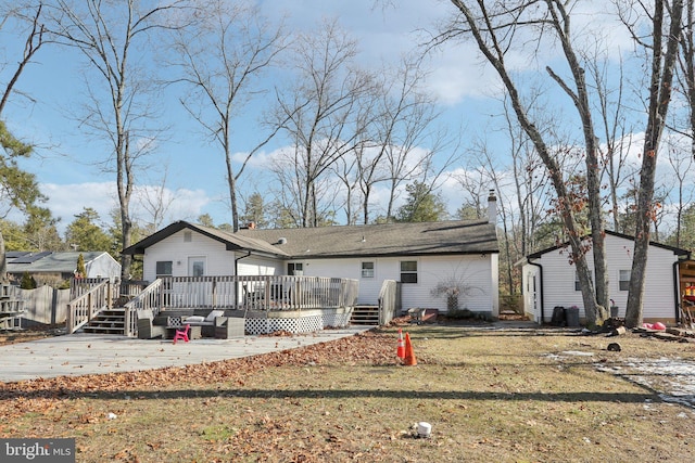 rear view of house with a patio, a deck, and a lawn