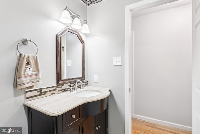 bathroom featuring vanity, backsplash, and hardwood / wood-style flooring