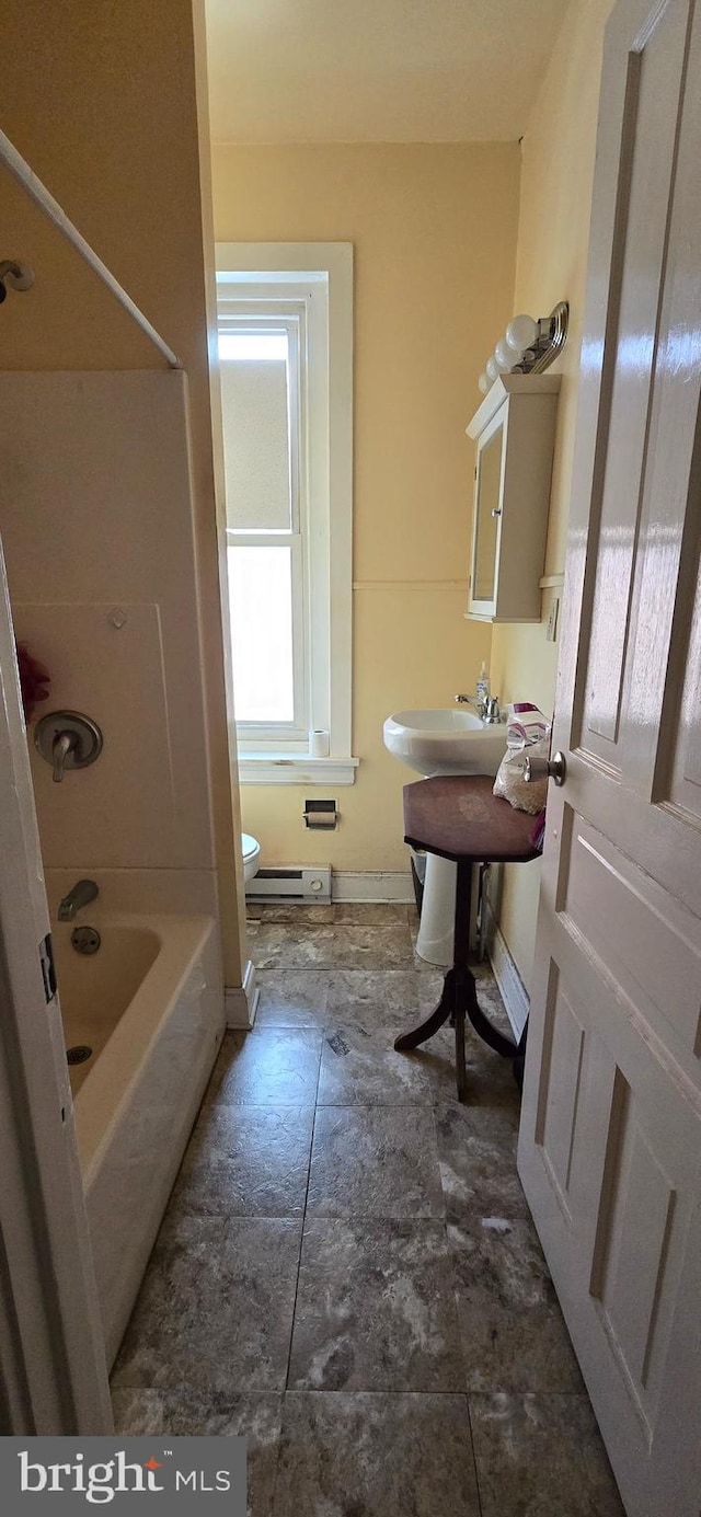 bathroom with a baseboard heating unit,  shower combination, and toilet