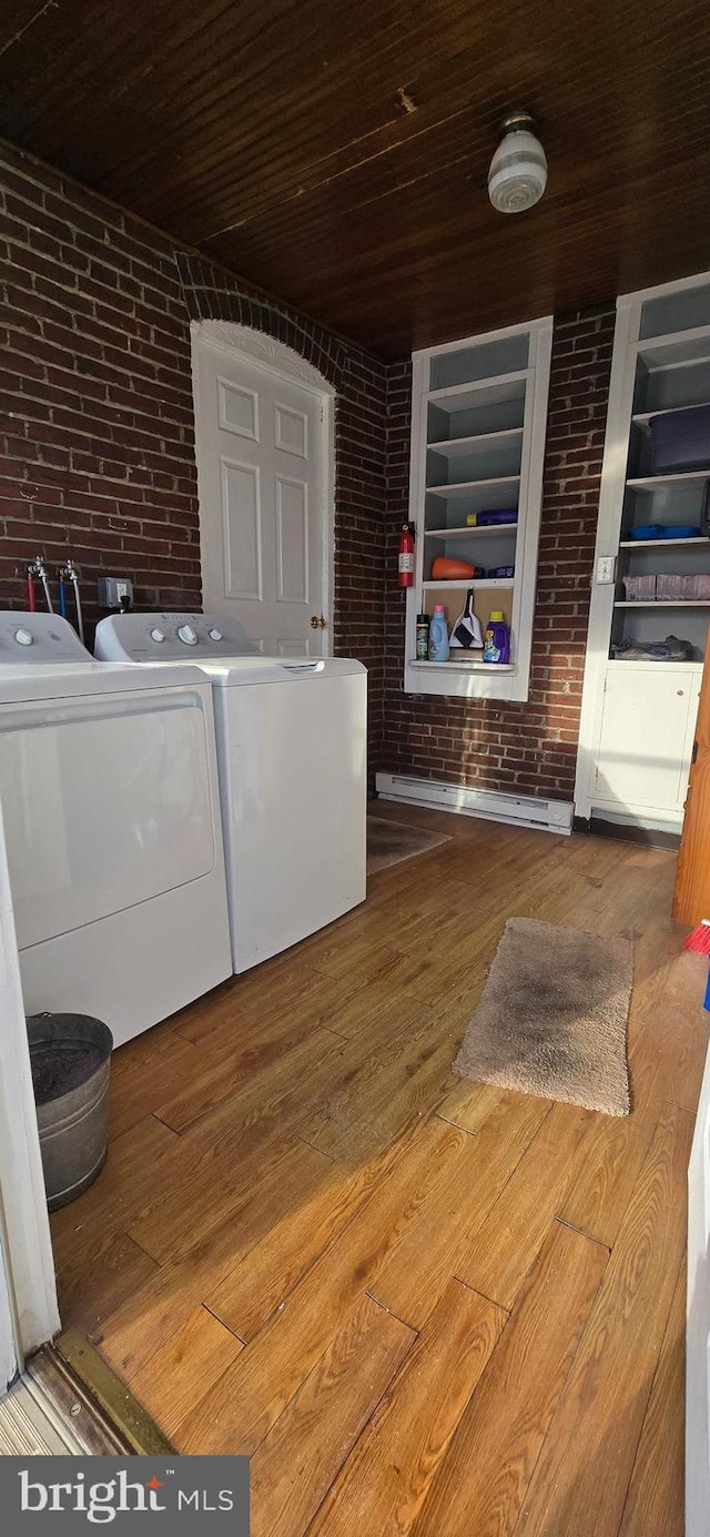 washroom with hardwood / wood-style flooring, brick wall, wooden ceiling, and washing machine and clothes dryer