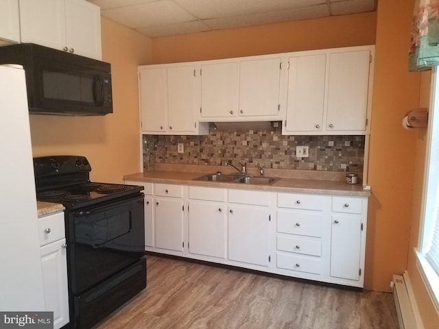 kitchen featuring tasteful backsplash, sink, white cabinets, a baseboard heating unit, and black appliances