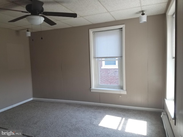 unfurnished room with a baseboard radiator, carpet flooring, a drop ceiling, and ceiling fan