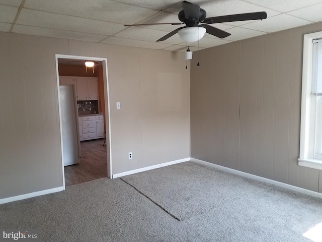 carpeted spare room with a paneled ceiling and ceiling fan