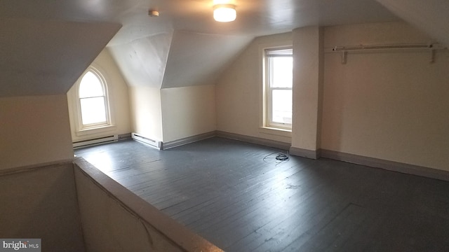 bonus room with vaulted ceiling, a baseboard heating unit, and dark wood-type flooring