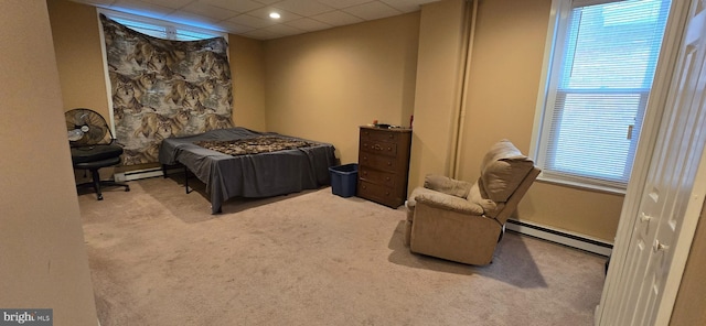 carpeted bedroom featuring a baseboard radiator and a drop ceiling