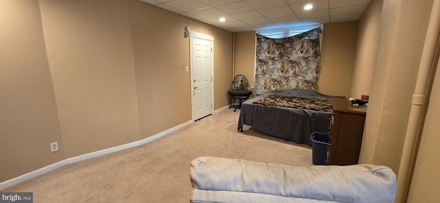 bedroom with light carpet and a drop ceiling