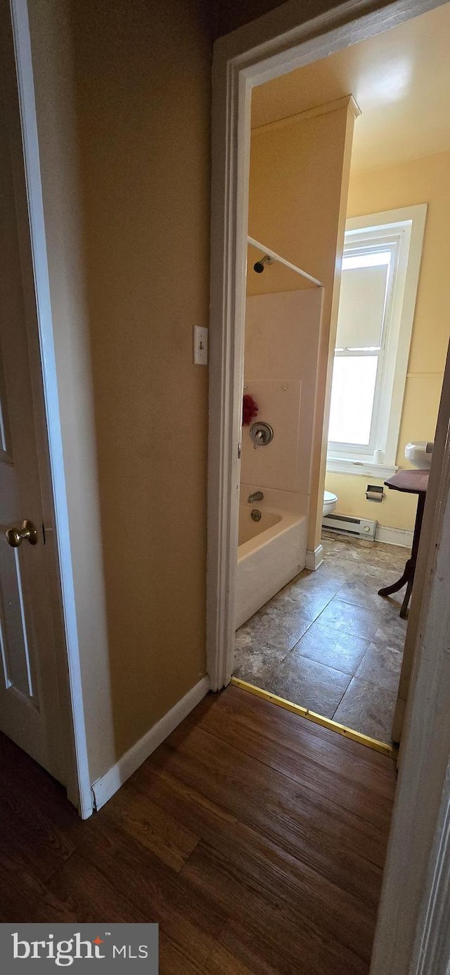 bathroom featuring hardwood / wood-style floors, tub / shower combination, toilet, and baseboard heating