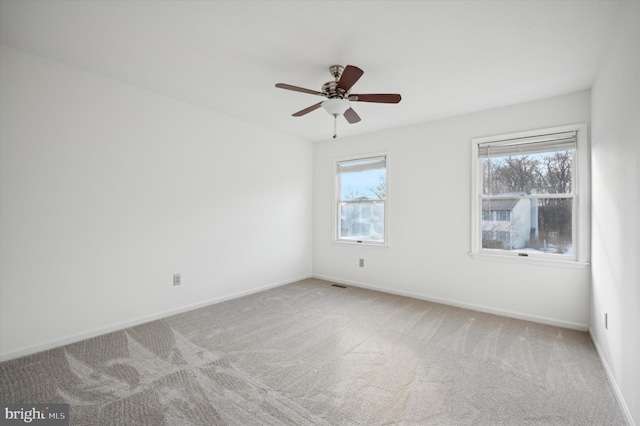 carpeted spare room with ceiling fan