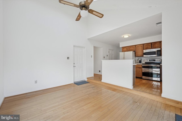 kitchen with ceiling fan, appliances with stainless steel finishes, and light hardwood / wood-style floors