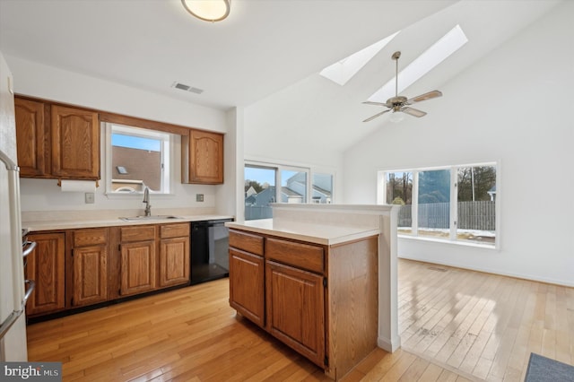 kitchen featuring black dishwasher, a skylight, sink, and a wealth of natural light