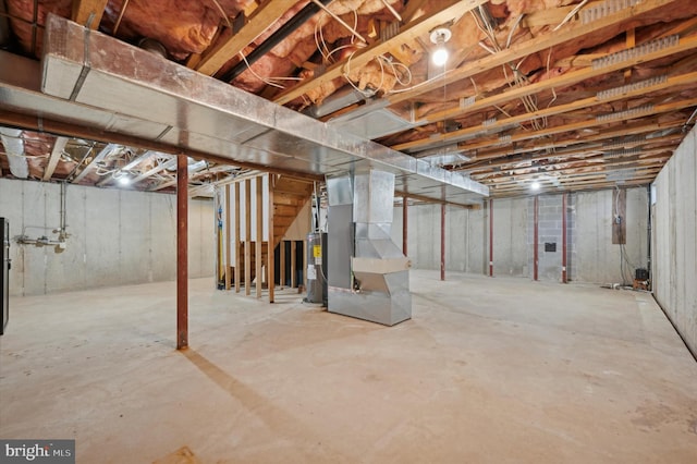 basement with electric water heater and heating unit