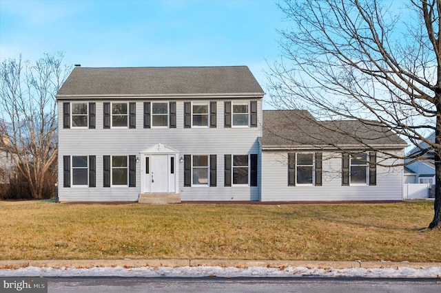 colonial-style house featuring a front lawn