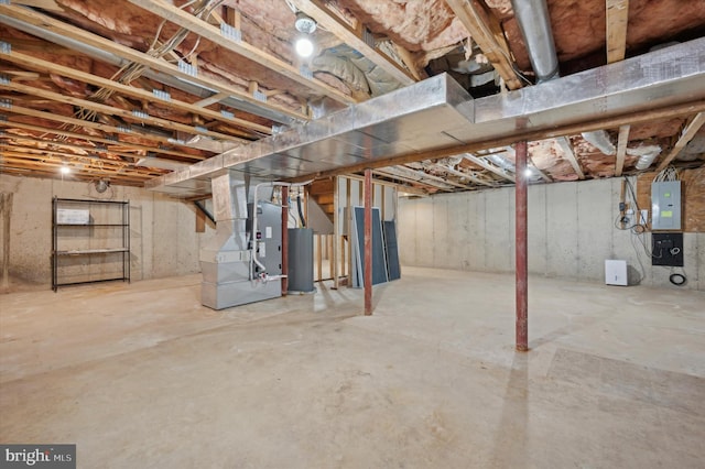 basement with gas water heater, heating unit, and electric panel