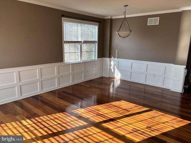 interior space with dark wood-style floors, a wainscoted wall, visible vents, and crown molding