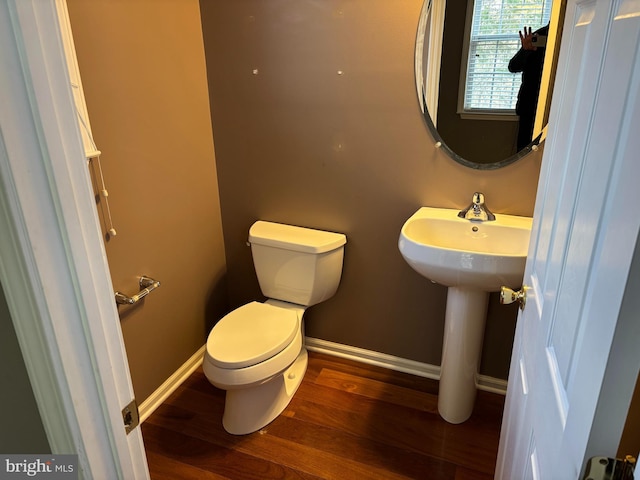 bathroom with a sink, wood finished floors, toilet, and baseboards