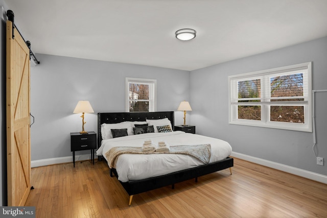 bedroom with hardwood / wood-style floors and a barn door